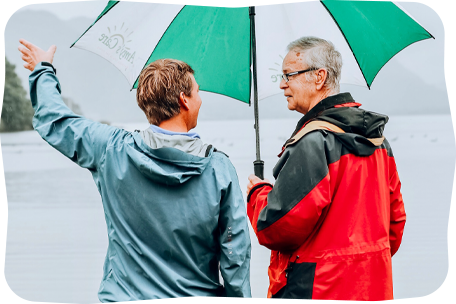 Two people standing under an umbrella