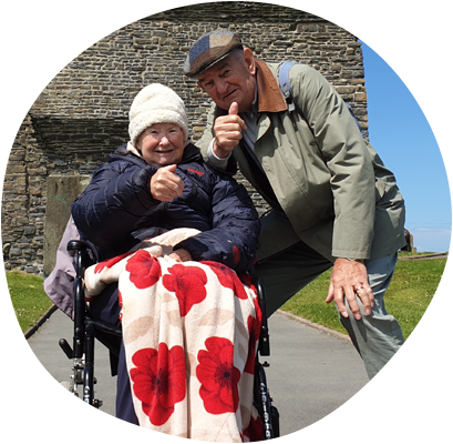 Elderly man and lady smiling with thumbs up