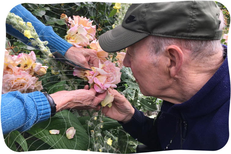 Man a smelling pink flower